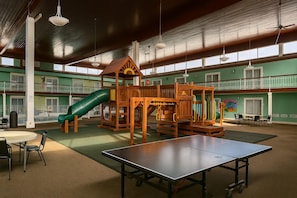 A spacious indoor play area with a slide, climbing structures, and a ping pong table. - Baymont by Wyndham Coldwater (Coldwater)