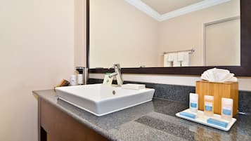 A bathroom with a white sink, a mirror, and a towel rack.