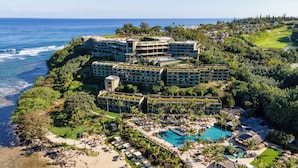 A resort with multiple buildings, a swimming pool, and a beach.