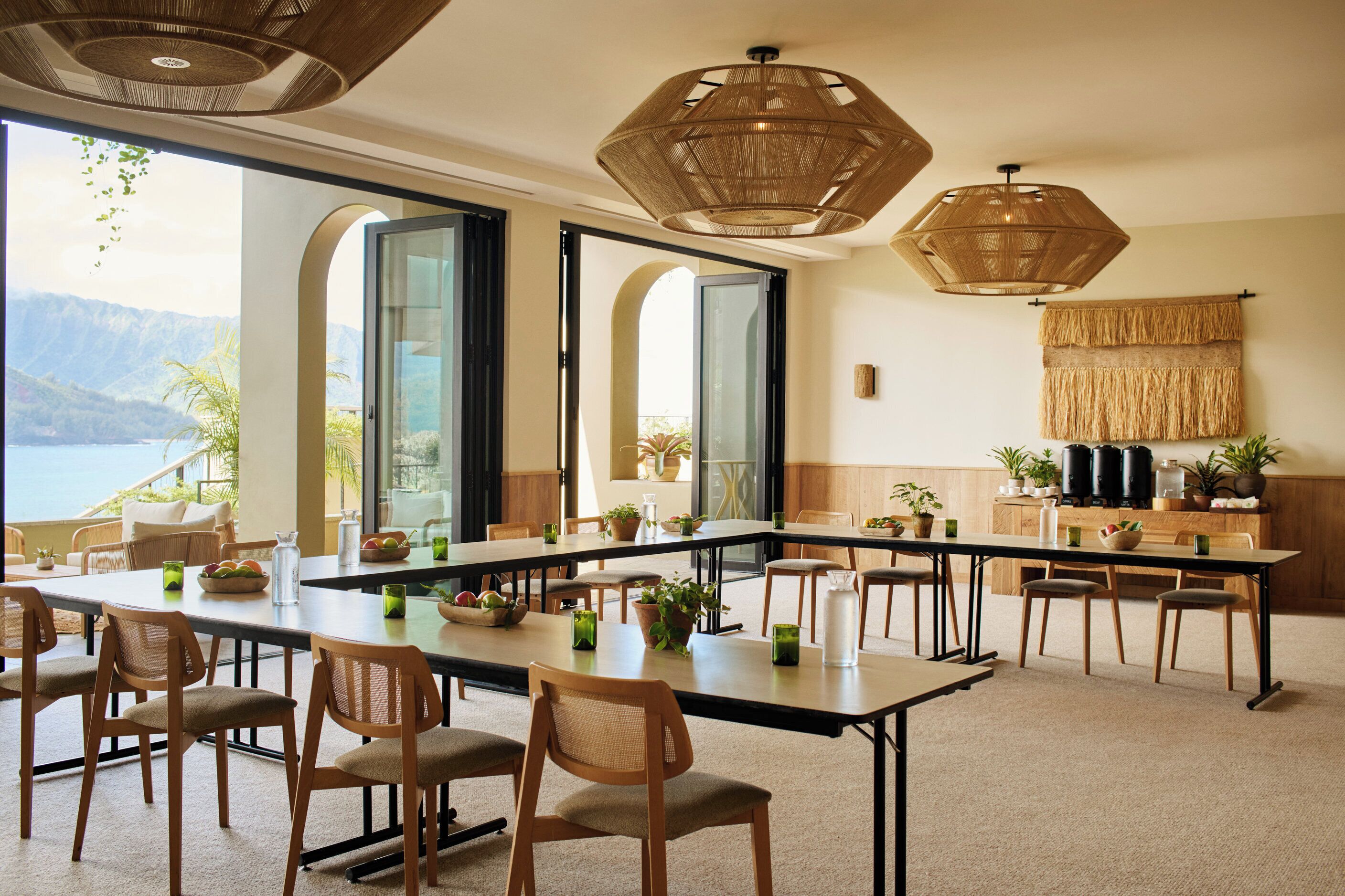A conference room with a long table, chairs, and potted plants.