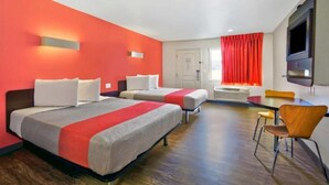 A hotel room with two beds, a dining table, and a TV. - Motel 6 Victorville - Desert Express (Victorville)