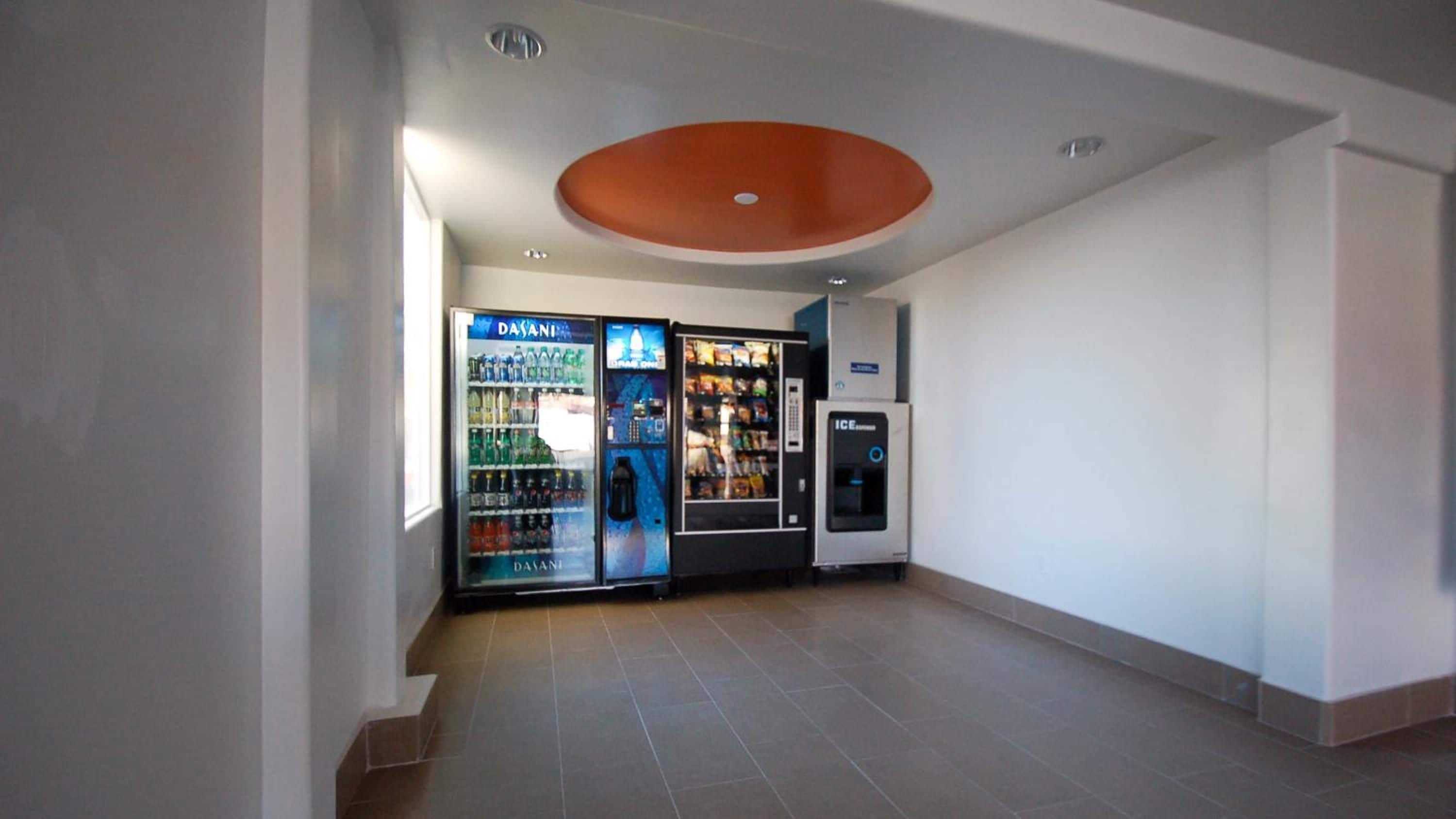 Ein sauberes, modernes Interieur mit Verkaufsautomaten und einem Kühlschrank.