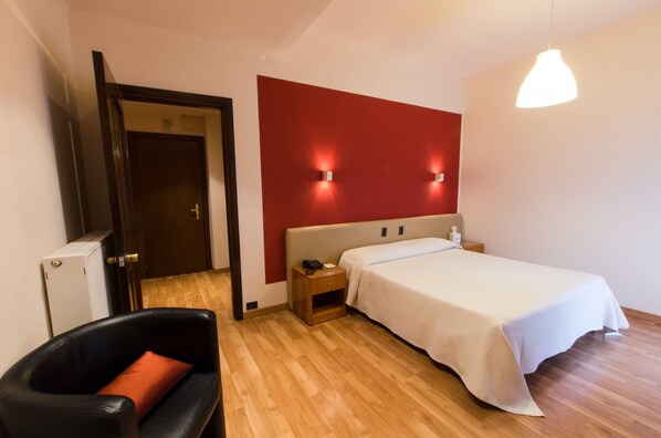 Relax in this stylish room with a comfortable bed, nightstand, and leather chair.