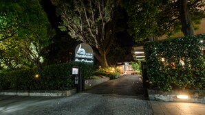 L’entrée d’un hôtel la nuit, avec une enseigne indiquant la présence d’un restaurant.