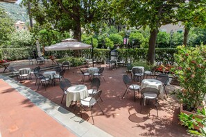 Relax in a serene outdoor space surrounded by lush greenery and comfortable seating.
