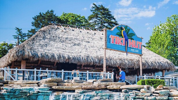 A thatched-roof building with a sign reading "TIKI HUT POOL BAR". - Margaritaville Lake Resort Lake of the Ozarks (Osage Beach)