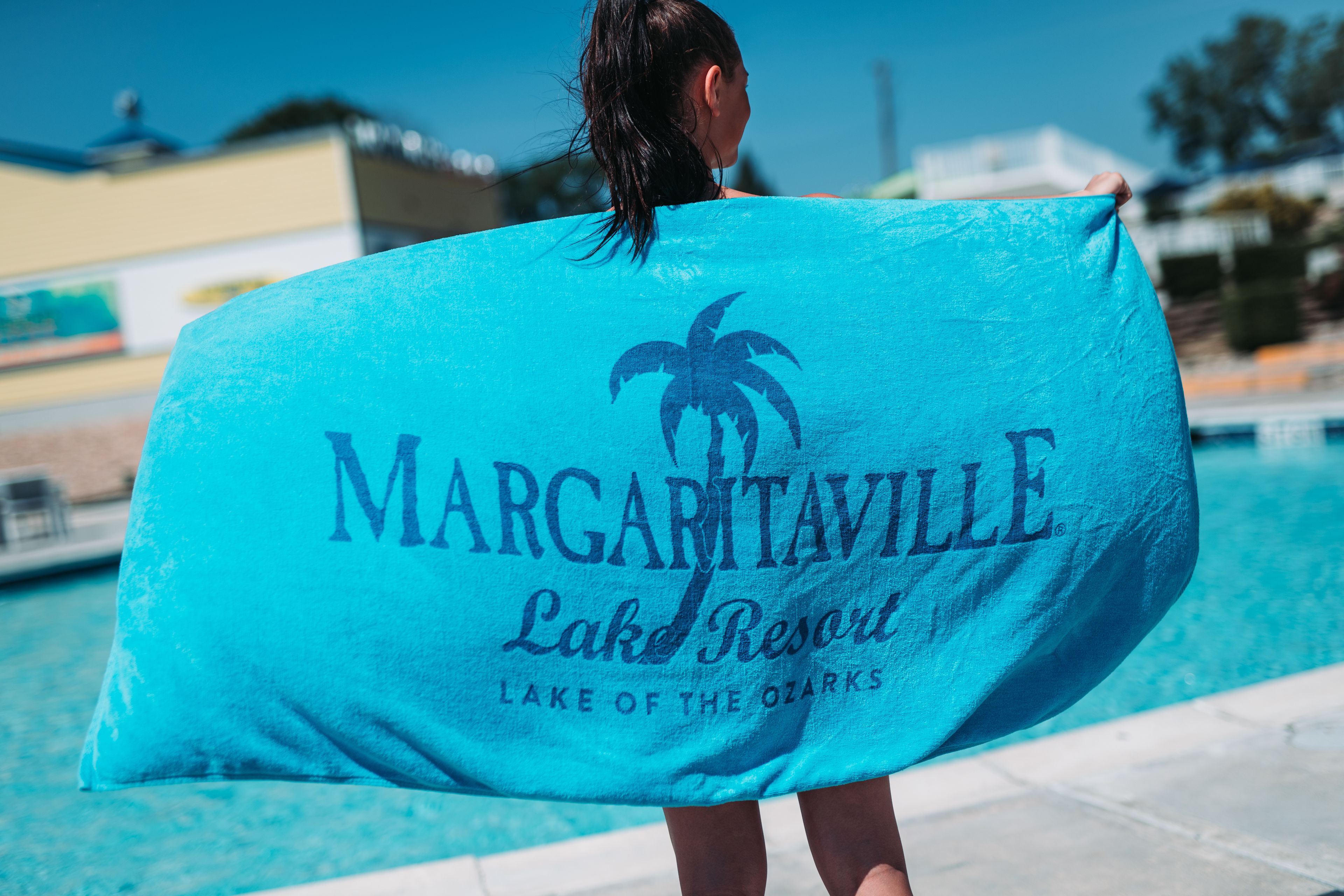 A person holding a towel with the text "Margaritaville Lake Resort" and "Lake of the Ozarks".