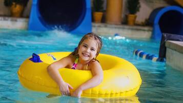 A child in a pool with a yellow inflatable ring.