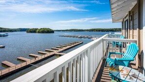 A deck with a view of a lake, dock, and chairs. - Margaritaville Lake Resort Lake of the Ozarks (Osage Beach)