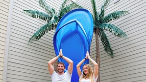 Two people standing in front of a building with a large blue sculpture. - Margaritaville Lake Resort Lake of the Ozarks (Osage Beach)