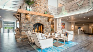 A spacious lobby with a stone fireplace, comfortable seating, and a large mural on the ceiling. - Margaritaville Lake Resort Lake of the Ozarks (Osage Beach)