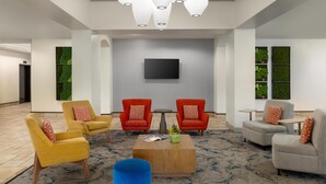 A lobby with modern furniture, a flat-screen TV, and decorative lighting. - Hilton Garden Inn Raleigh-Durham/Research Triangle Park (Durham)