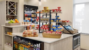 A well-stocked kitchen area with various food items, beverages, and a wine rack. - Hilton Garden Inn Raleigh-Durham/Research Triangle Park (Durham)
