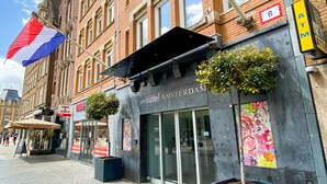 A hotel with a red and white flag, a sign for tours and tickets, and a flower-adorned wall. - Swissôtel Amsterdam (Amsterdam)