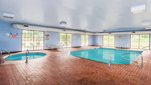 Una piscina interior con dos secciones separadas, cada una con sus propias escaleras y barandillas.