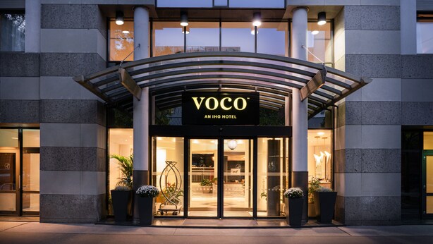 The exterior of the VOCO An IHG Hotel with a modern design, featuring a prominent entrance, large windows, and potted plants. - voco Vienna Prater by IHG (Vienna)