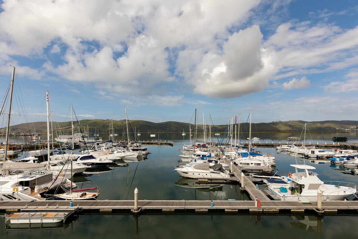 Un puerto deportivo con varios barcos amarrados a muelles de madera.