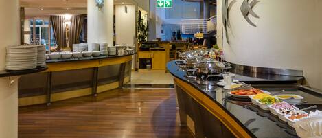 A buffet area with various food items and a counter with plates.