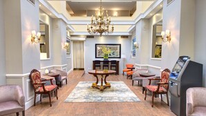A hotel lobby with a chandelier, a round table, and multiple chairs. - The Roslyn, Tapestry Collection by Hilton (Roslyn)
