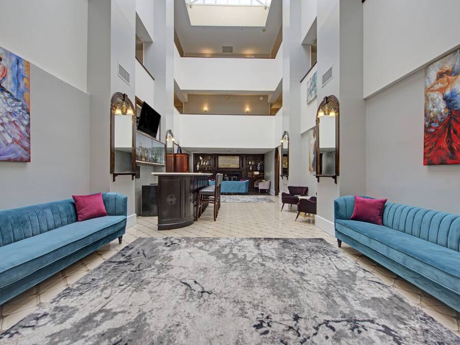 A spacious atrium with high ceilings, a central seating area, and artwork on the walls.
