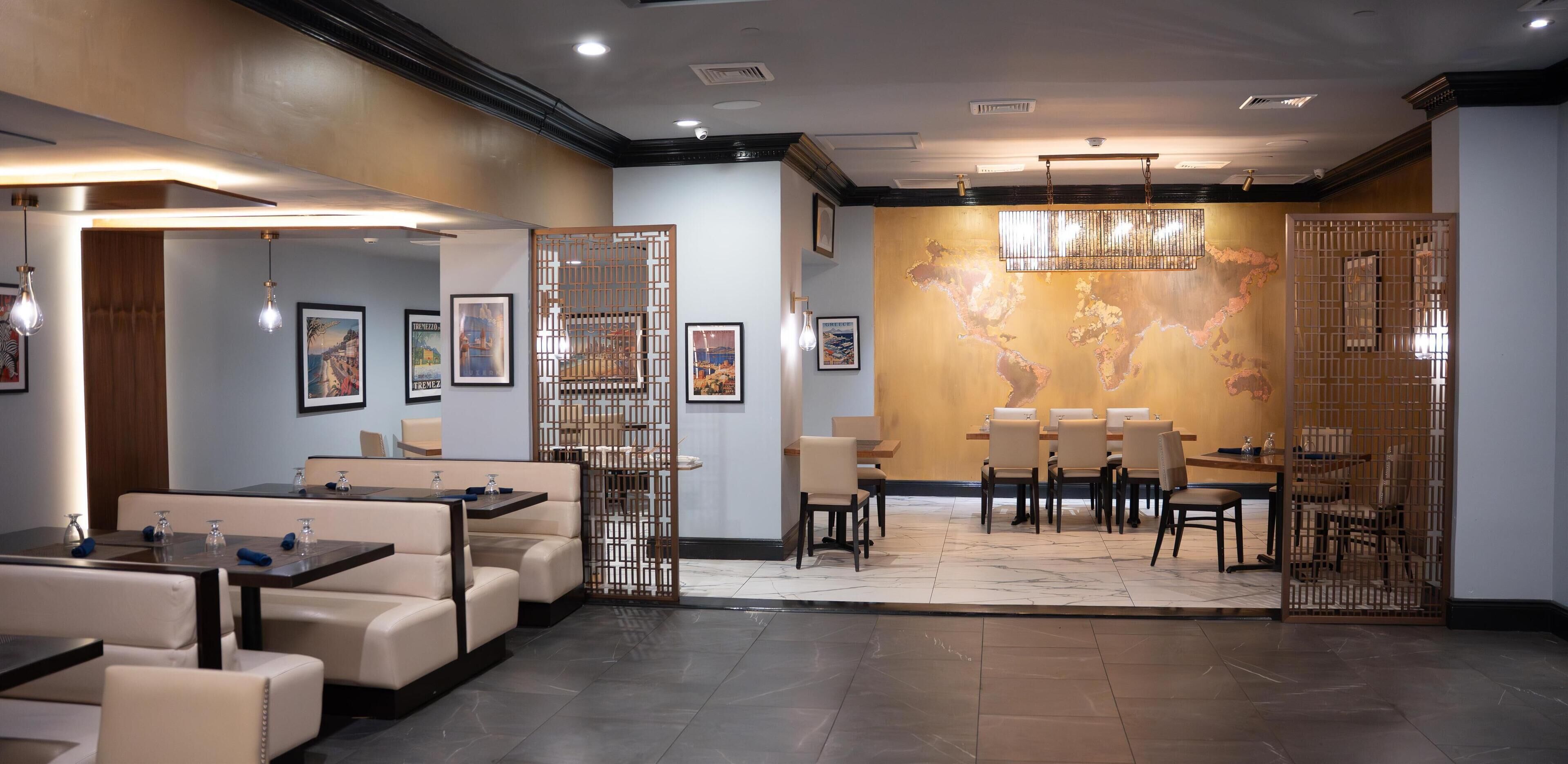 A modern dining area with a world map mural, cushioned seating, and ambient lighting.