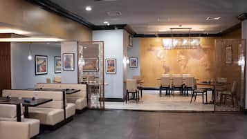 A modern dining area with a world map mural, cushioned seating, and ambient lighting.