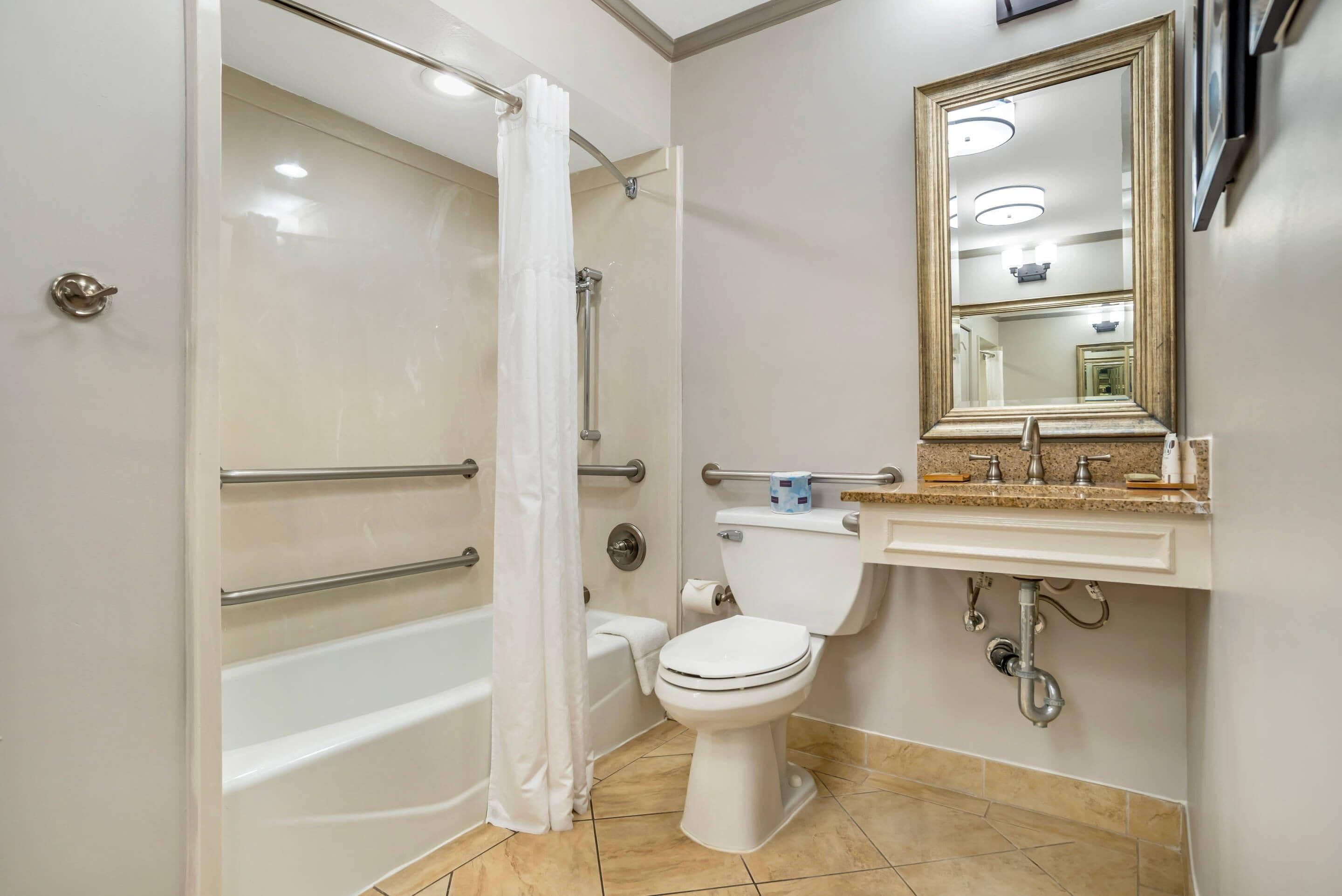 A bathroom with a bathtub, toilet, and sink.