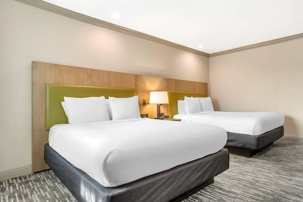 A hotel room with two beds, a headboard, bedside lamps, and a carpeted floor. - Country Inn & Suites by Radisson, Metairie (New Orleans), LA (Metairie)