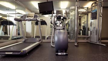 A gym with treadmills, elliptical machines, and weightlifting equipment.