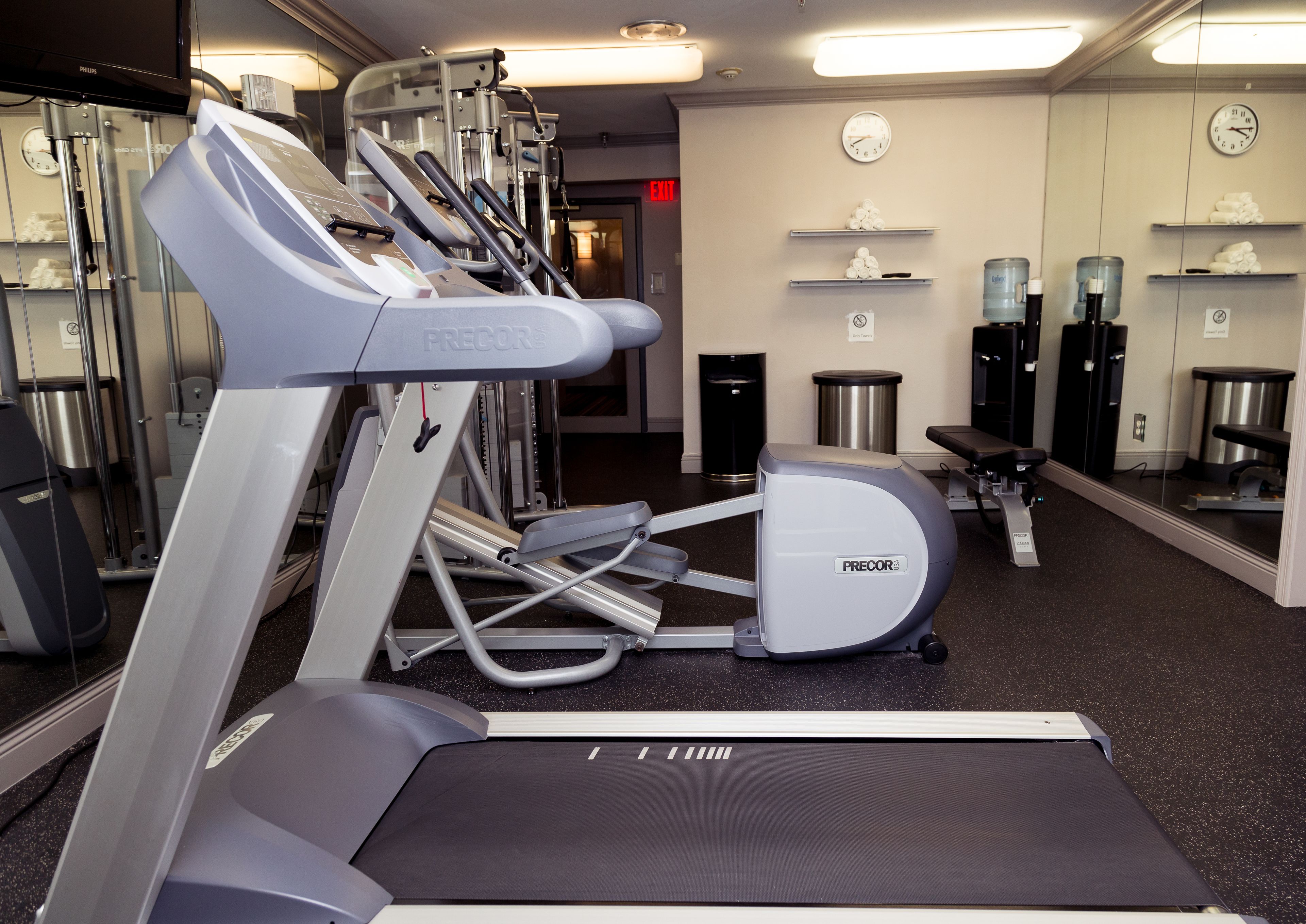 Ein Fitnessstudio mit Laufbändern, Crosstrainern und Gewichten.
