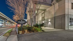 En byggnad med en skylt som visar texten ”Country Inn & Suites”, och en parkeringsanläggning syns i bakgrunden.