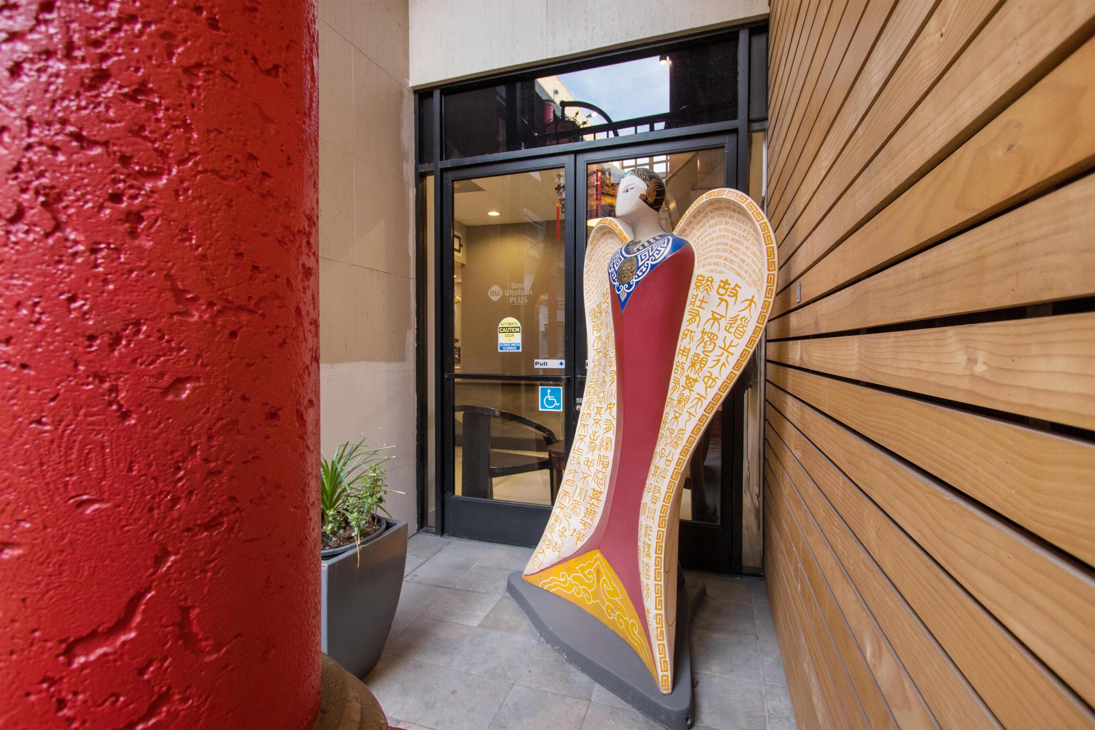 A building entrance with a large decorative sculpture and a wheelchair-accessible sign.