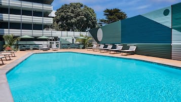 Relax by the pool surrounded by comfortable lounge chairs and umbrellas.