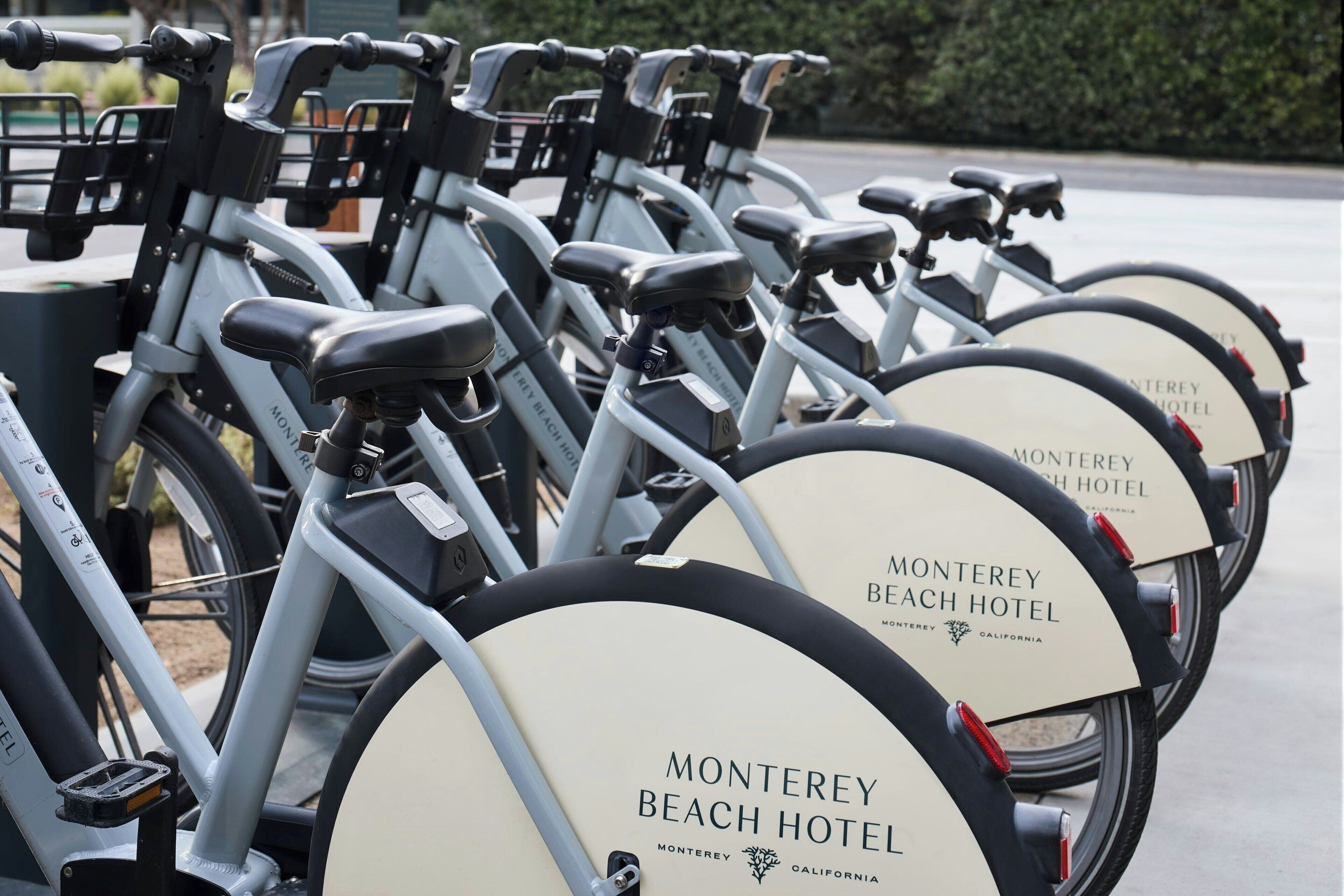 A row of bicycles with "Monterey Beach Hotel" branding, indicating a bike rental service at the hotel.