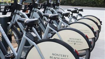 A row of bicycles with "Monterey Beach Hotel" branding, indicating a bike rental service at the hotel.