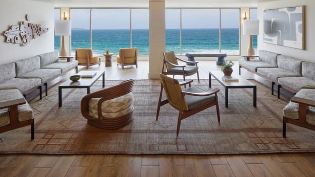 A spacious living area with a large view of the ocean, furnished with sofas, chairs, and tables. - Monterey Beach Hotel, A Tribute Portfolio Hotel (Monterey)