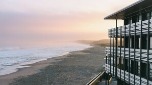 A coastal building with a balcony overlooking a beach. - Monterey Beach Hotel, A Tribute Portfolio Hotel (Monterey)