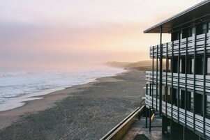 Un edificio frente al mar con un balcón que da a la playa.