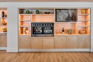 A bar area with shelves of wine glasses, bottles, and decorative items.