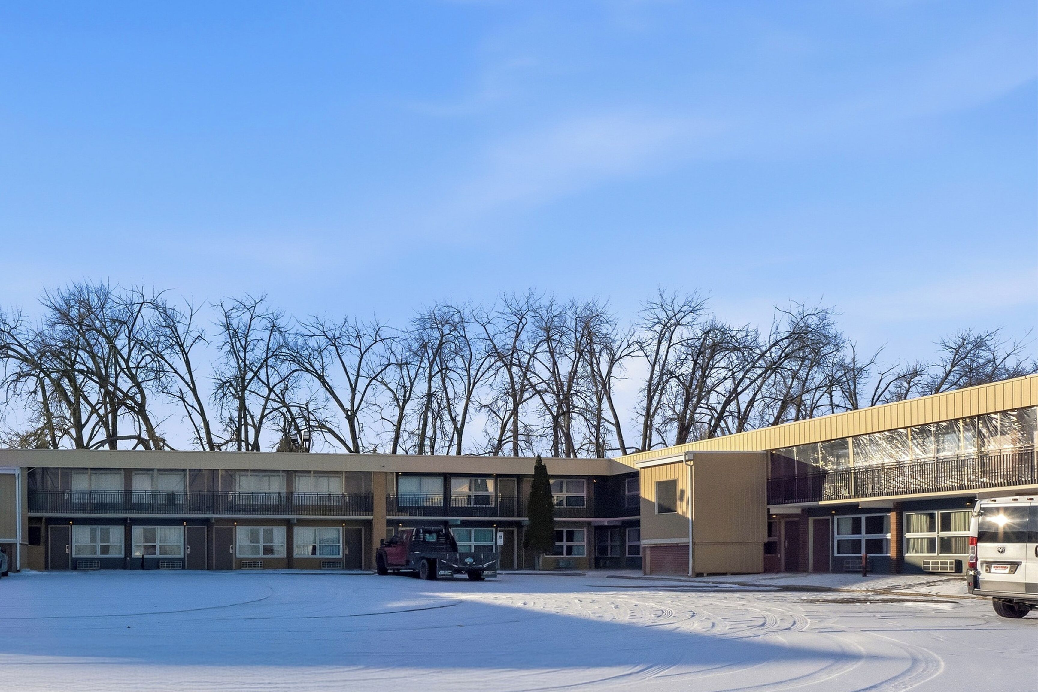 A multi-story building with a parking lot in front.