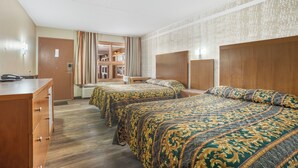 Habitación de hotel con dos camas, un aparador de madera y un escritorio con teléfono.