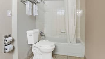Une salle de bain équipée de toilettes, d’une baignoire et d’un rideau de douche.