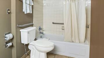 A bathroom with a toilet, a bathtub, and a shower curtain.