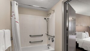 A hotel bathroom with a bathtub, shower, and handrails. - Red Roof Inn Enfield (Enfield)