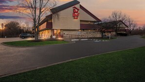 A Red Roof Inn with a stone facade, a parking lot, and a grassy area in front. - Red Roof Inn Enfield (Enfield)