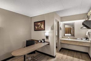 Une chambre d’hôtel équipée d’un bureau, d’une chaise et d’un grand miroir.