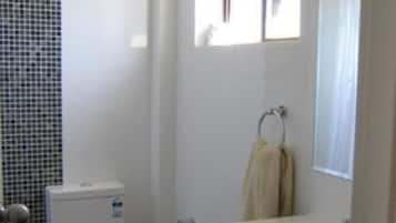 Une salle de bain avec des toilettes, un lavabo et un miroir.