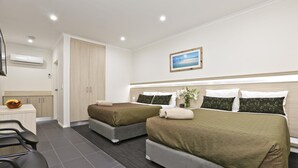 A hotel room with two beds, a desk, and a bathroom. - Morphettville Motor Inn (Camden Park)