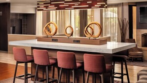A modern kitchen with a large island, bar stools, and a pendant light fixture.