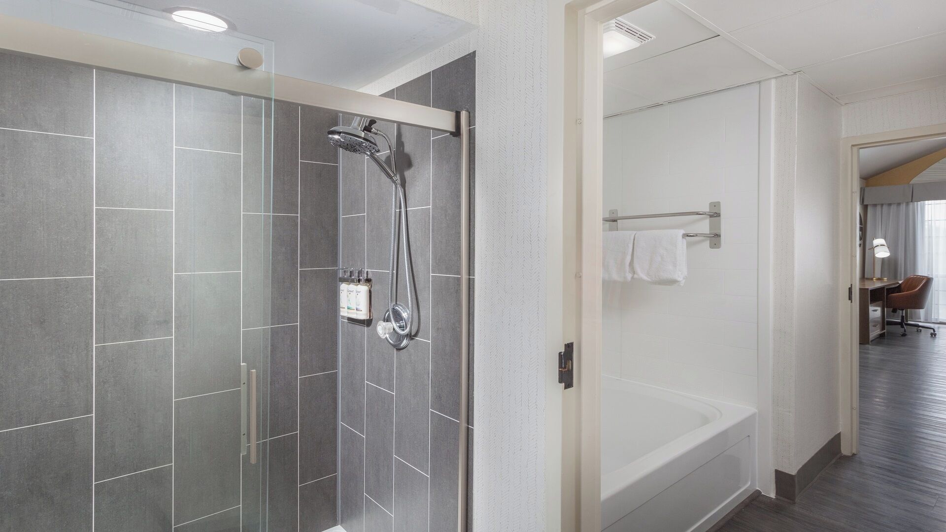 A modern bathroom with a glass-enclosed shower, a bathtub, and a walk-in shower.